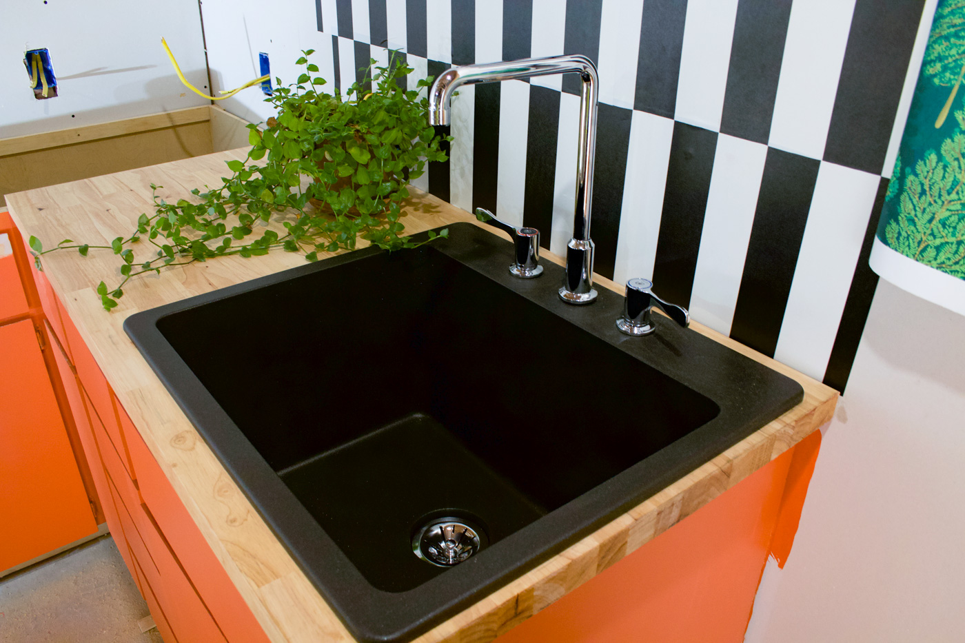 black-quartz-sink-elkay-with-orange-cabinets-by-banyan-bridges