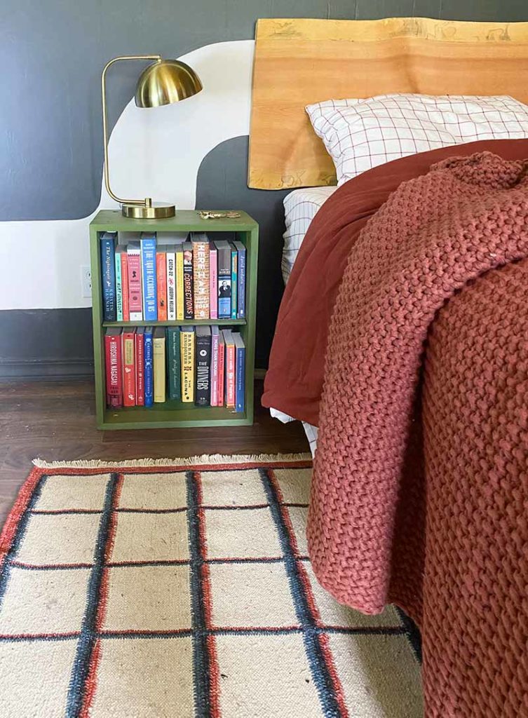 The Norman Flatweave rug from Revival Rugs next to a bedside with a custom mural from Banyan Bridges.