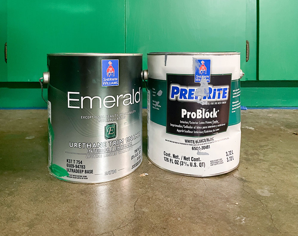 Sherwin Williams primer and paint cans in front of green cabinets